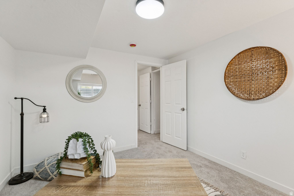 Interior space with baseboards and light carpet