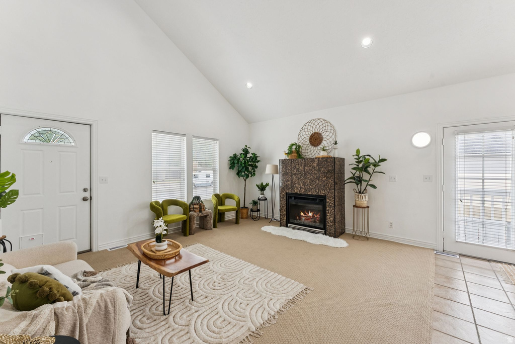Living area with light carpet, lofted ceiling, a glass covered fireplace, and recessed lighting