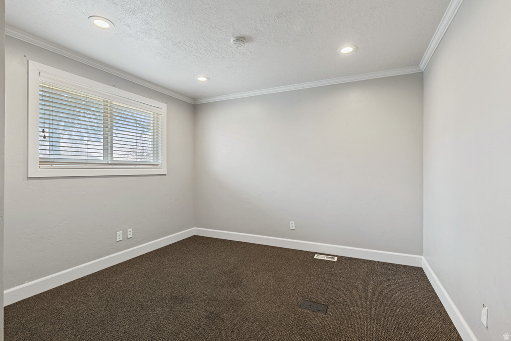 Unfurnished room featuring dark carpet, recessed lighting, ornamental molding, and a textured ceiling