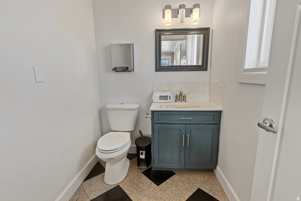 Half bathroom with vanity and toilet