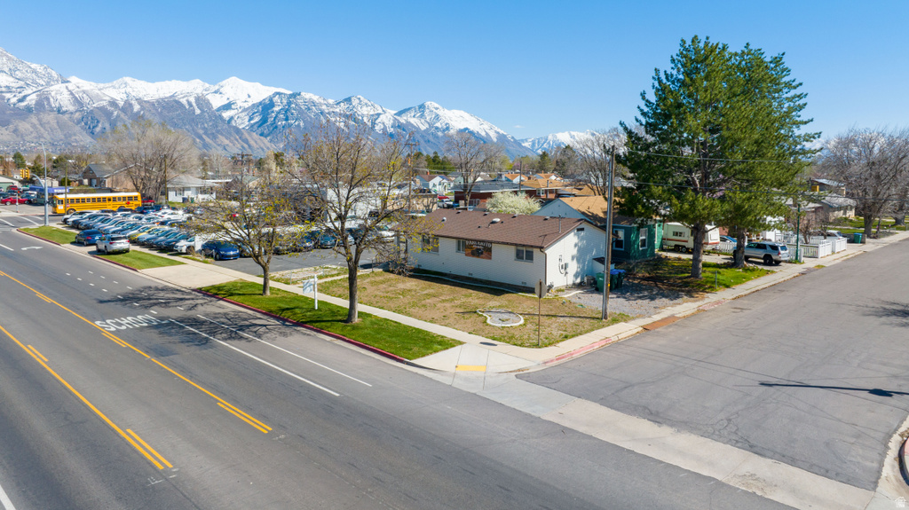 View of asphalt road featuring a residential view, curbs, and a mountain view