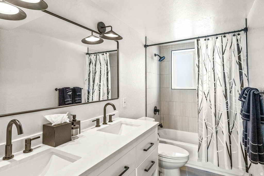 Bathroom featuring shower / tub combo with curtain and double vanity