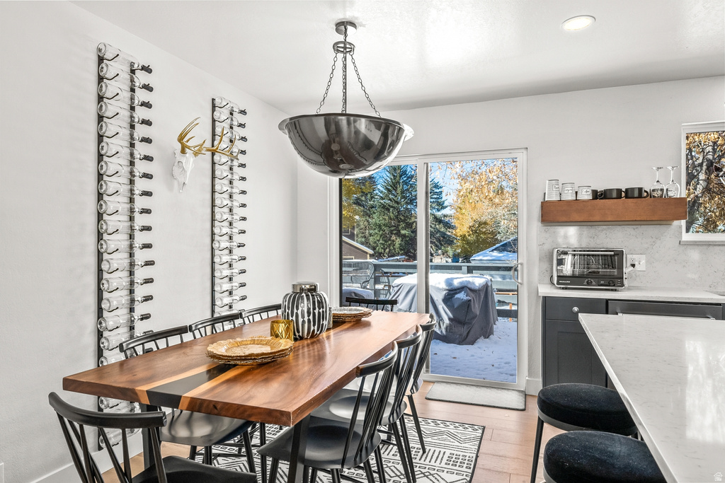 Dining room with light wood finished floors and recessed lighting