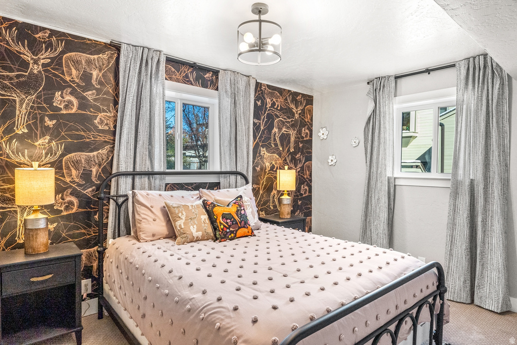 Carpeted bedroom with a chandelier