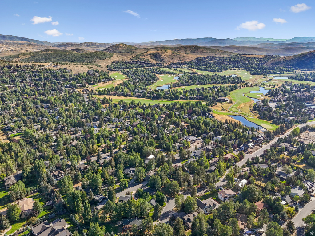 Aerial overview of property's location featuring a water and mountain view and nearby suburban area