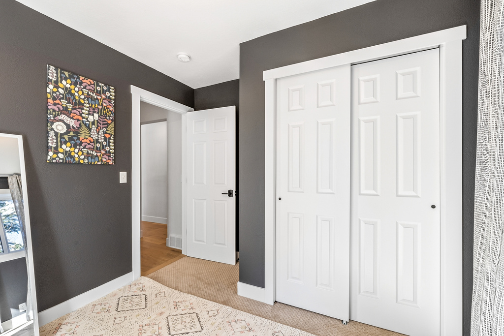 Unfurnished bedroom featuring a closet and light carpet