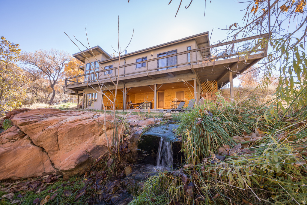 Rear view of property featuring a wooden deck and stucco siding