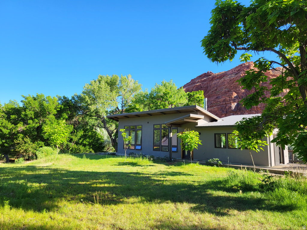 View of front facade featuring a front lawn and stucco siding