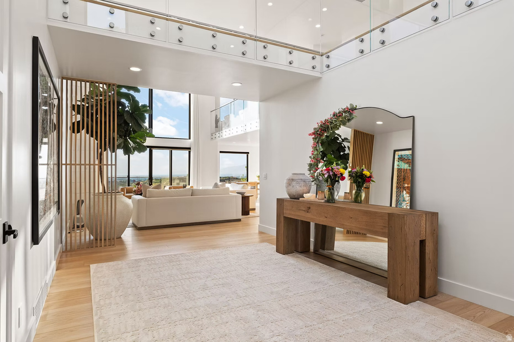 Foyer with a high ceiling, light wood-type flooring, and recessed lighting