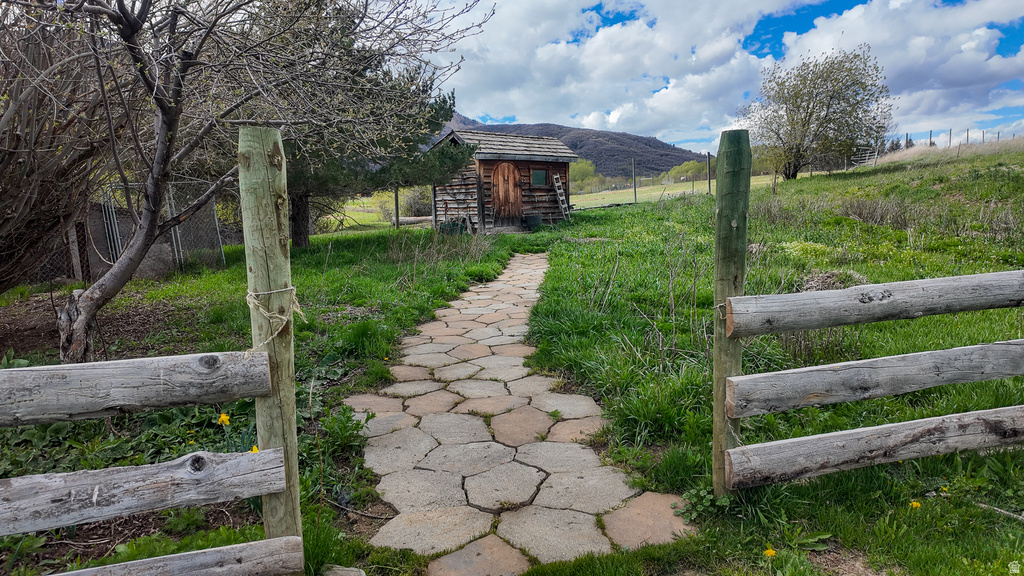 View of yard with a mountain view, an outbuilding, and a view of countryside