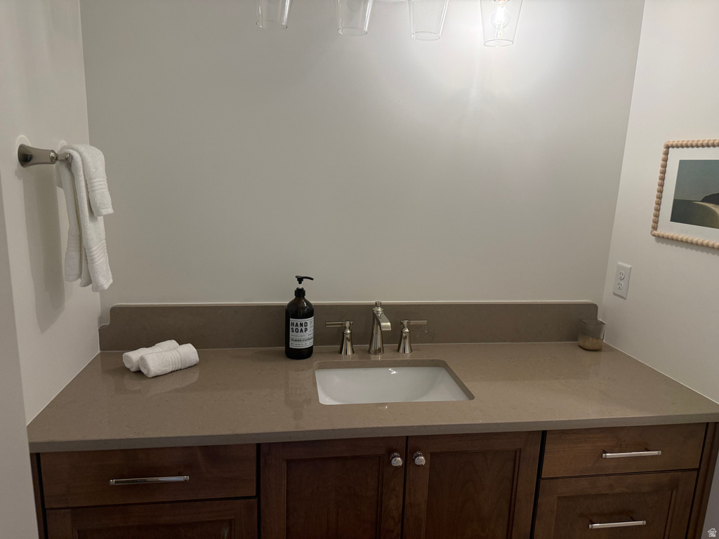 Wood-finish vanity with a light-colored countertop and an undermount sink