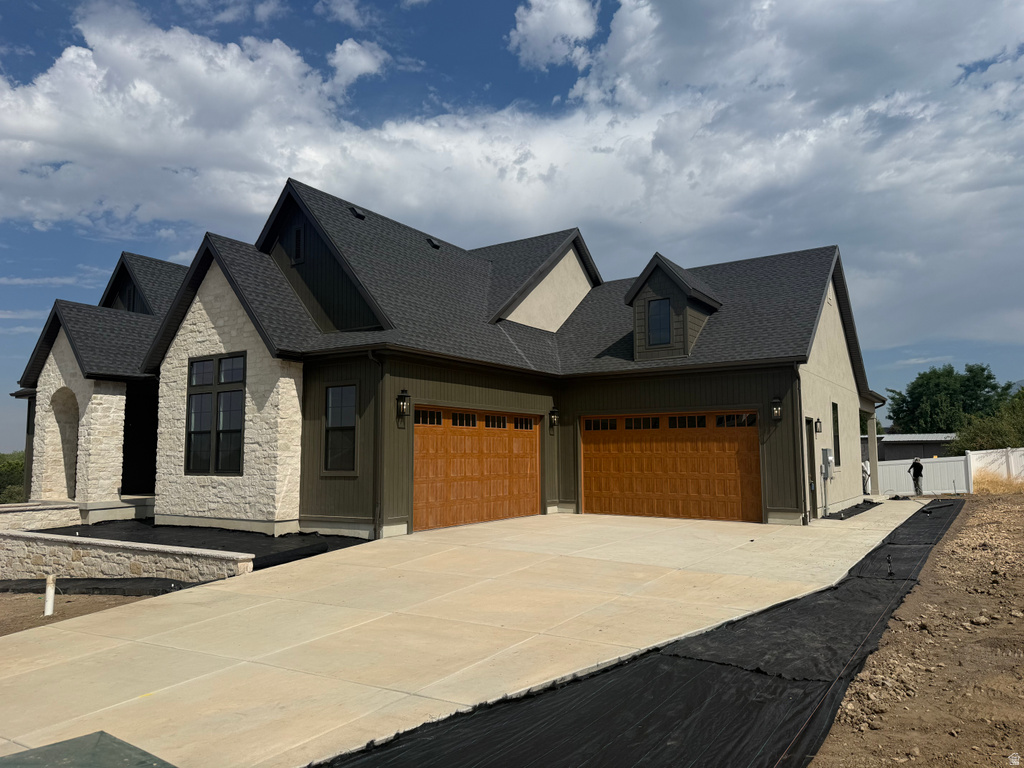 Contemporary exterior featuring stone accents, dark siding, and a dark shingle roof