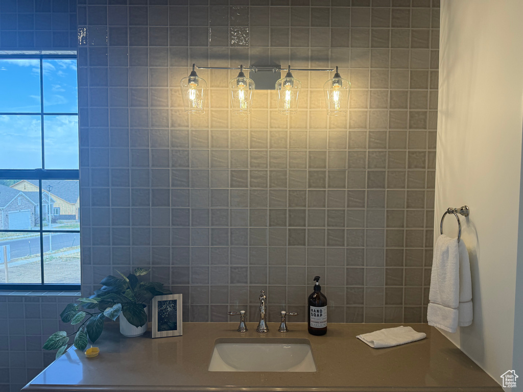 Bathroom vanity featuring a vessel sink, a flat-panel window, a four-light fixture, and square wall tiling