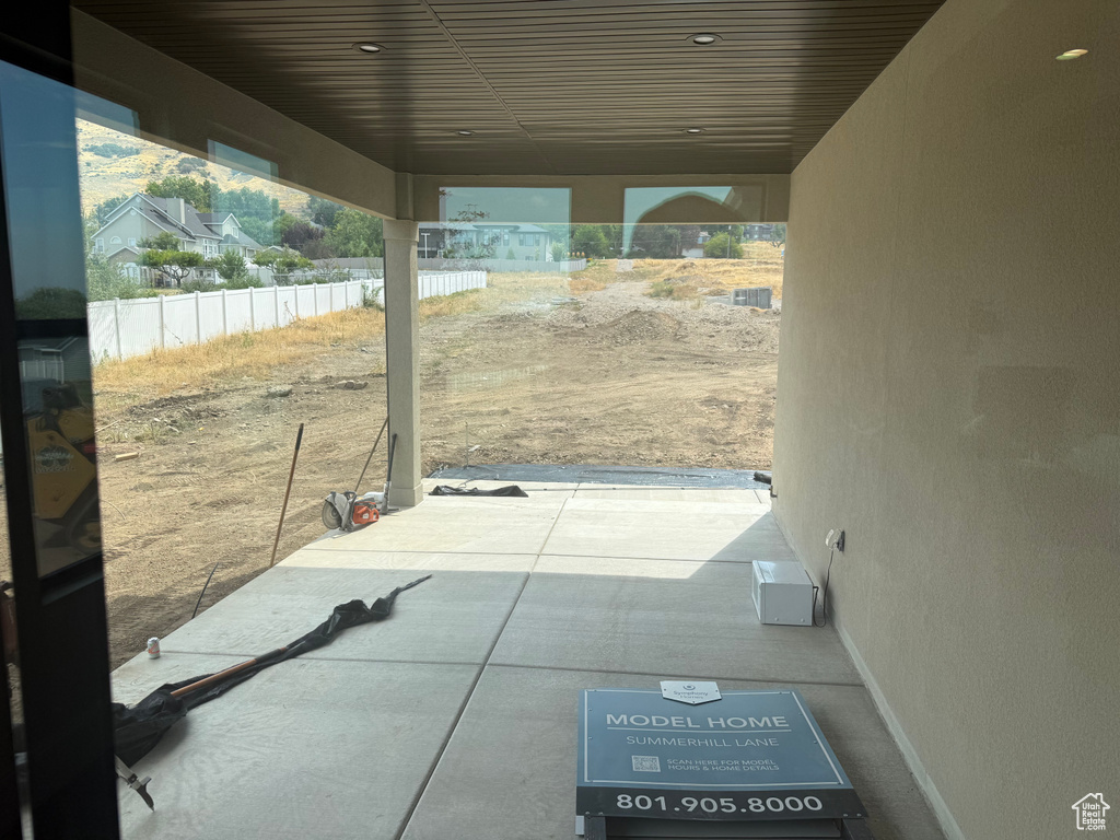 Covered patio with recessed lighting, concrete flooring, and an expansive undeveloped exterior space