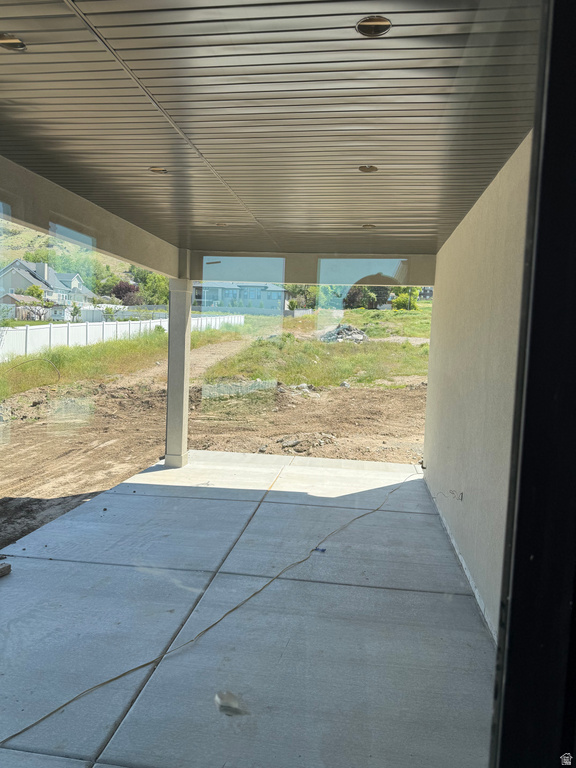 Covered concrete patio with recessed lighting and a stucco exterior