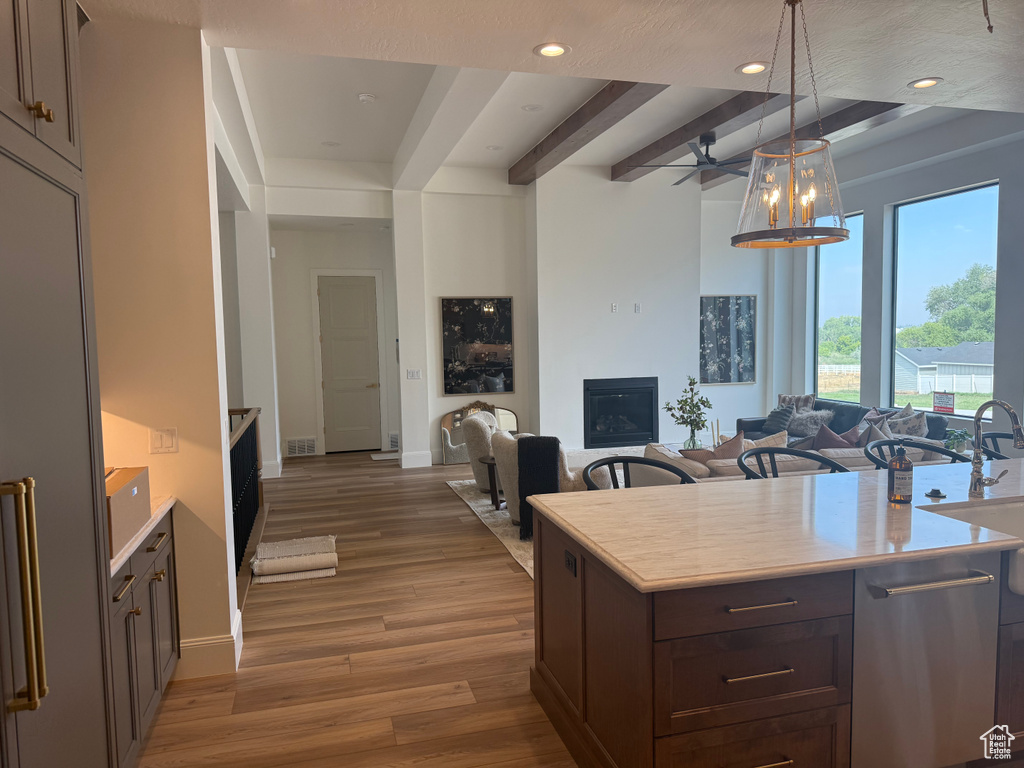Open-concept living space featuring wood-finish flooring, a fireplace, and large windows