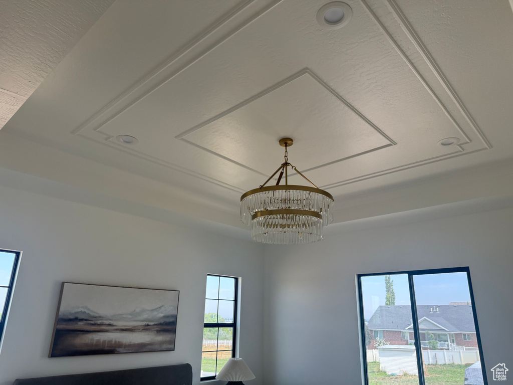 Tray ceiling with decorative molding, featuring a tiered crystal chandelier and recessed lighting
