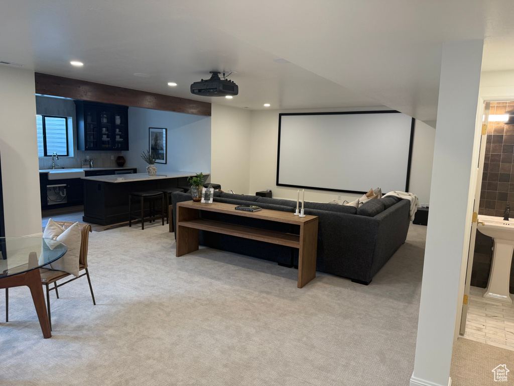 Entertainment area featuring a large projection screen and a built-in wet bar with dark cabinetry and a light-colored countertop