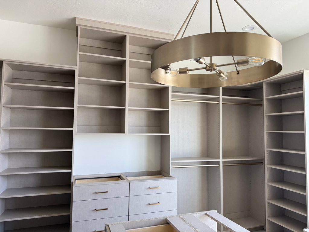Custom-built organizational system featuring extensive shelving, multiple hanging rods, and integrated drawer units
