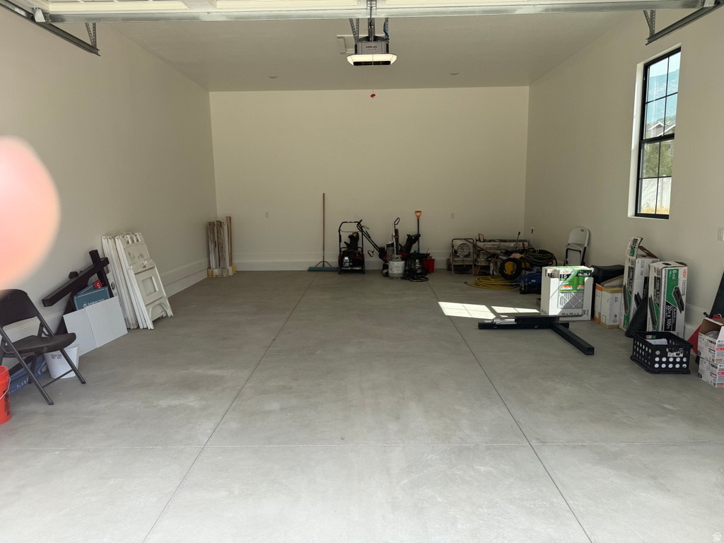Spacious garage featuring a concrete floor, painted walls, and a large window with black framing