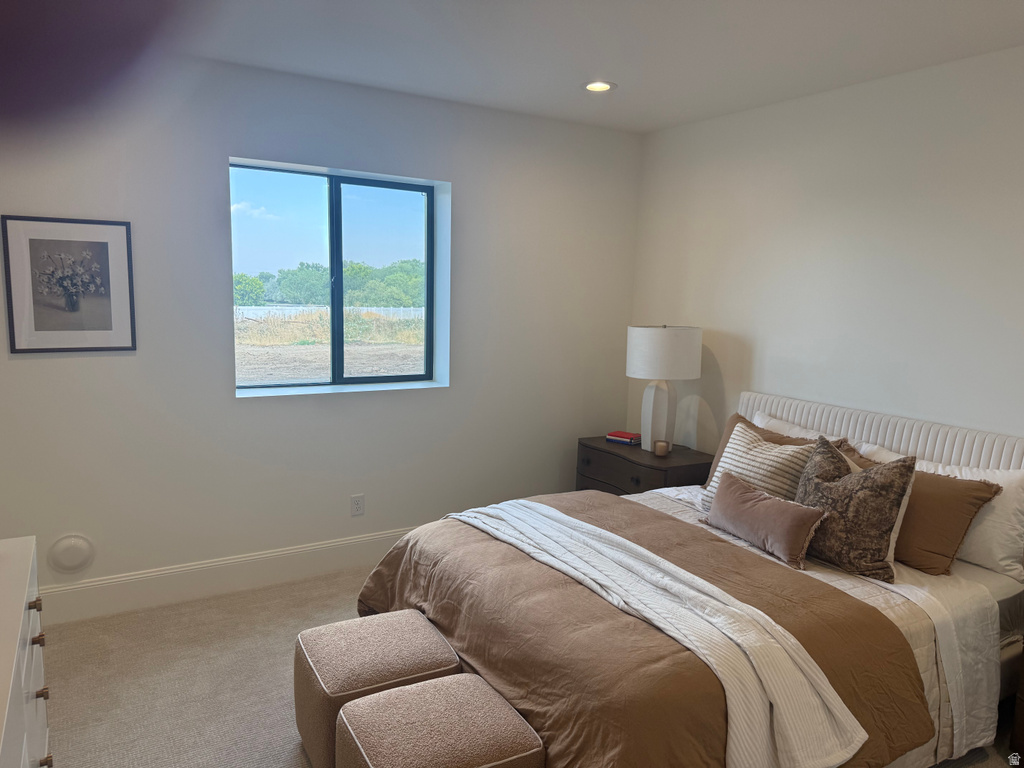 Recessed lighting illuminates neutral-toned walls and plush carpeting