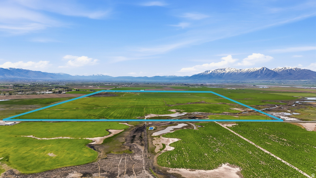 Expansive agricultural land featuring a rectangular parcel outlined in blue, surrounded by green fields