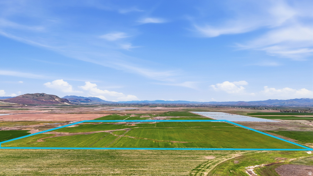 Expansive agricultural land featuring verdant fields and distant mountain ranges