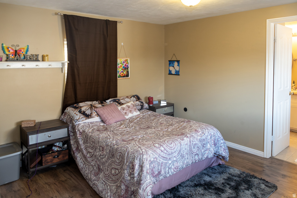 Bedroom featuring dark wood-style flooring and ensuite bath