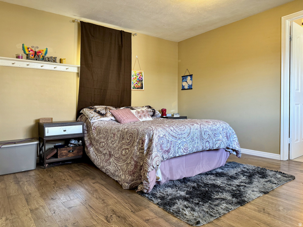 Bedroom with wood-type flooring and baseboards