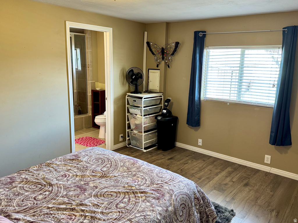 Bedroom with dark wood-style floors and ensuite bathroom