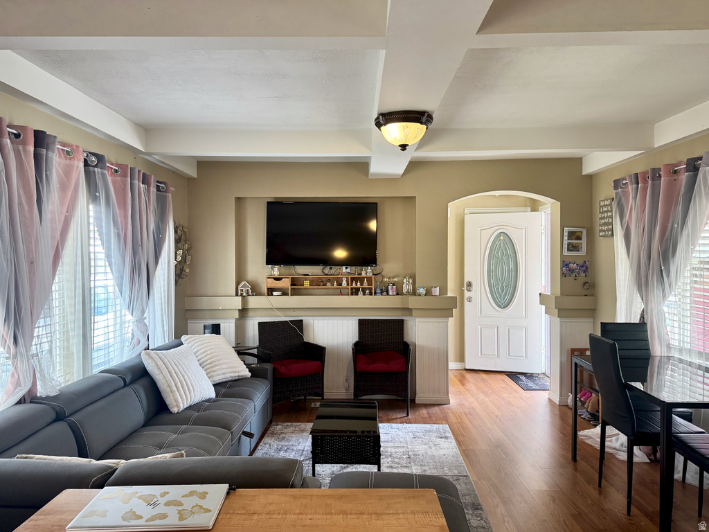 Living room with beamed ceiling and wood finished floors