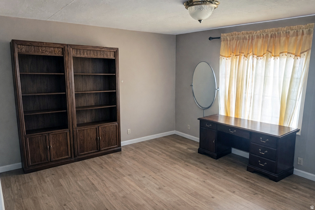 Unfurnished office featuring light wood finished floors and baseboards