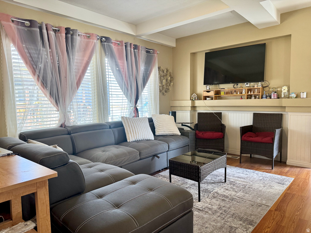 Living room featuring beamed ceiling and wood finished floors