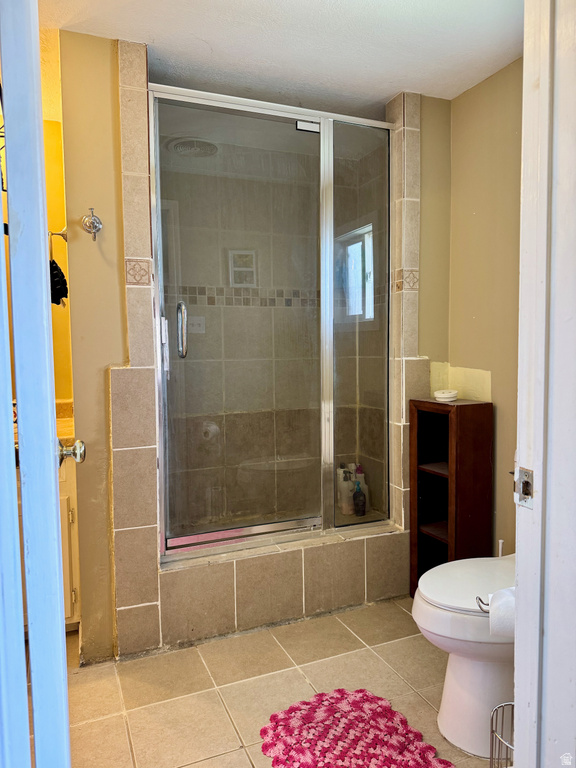 Bathroom with a shower stall and light tile patterned floors