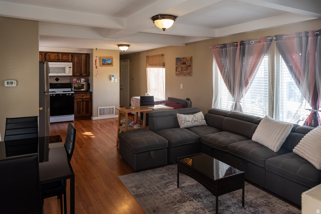 Living area featuring beamed ceiling and dark wood-style flooring