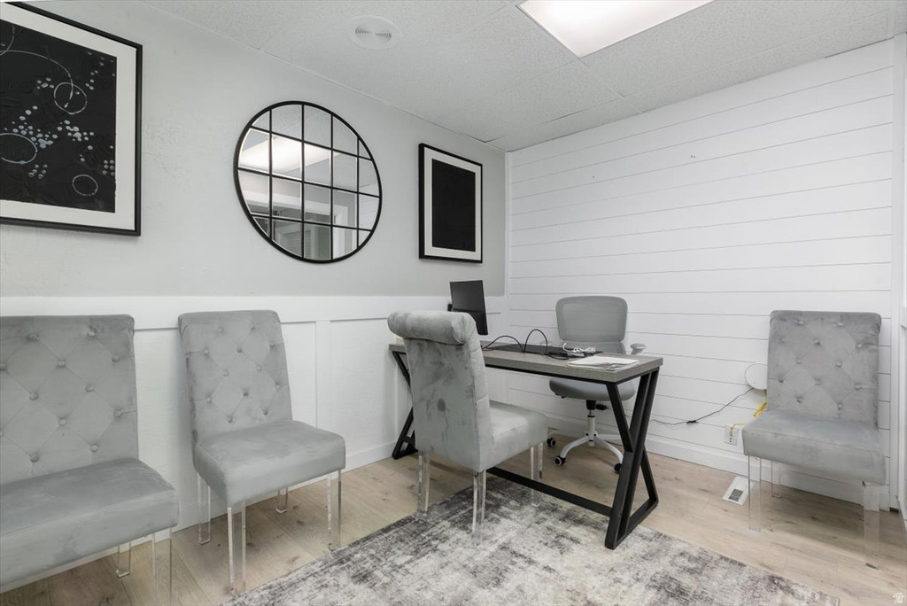 Office with wood finished floors and a wainscoted wall