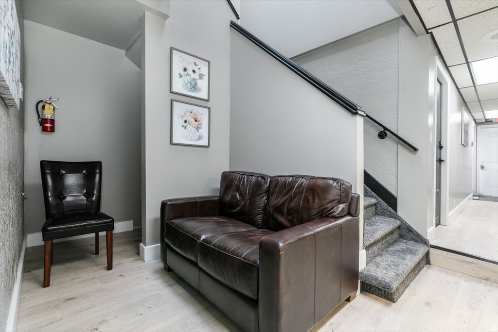 Living area featuring light wood finished floors and a drop ceiling