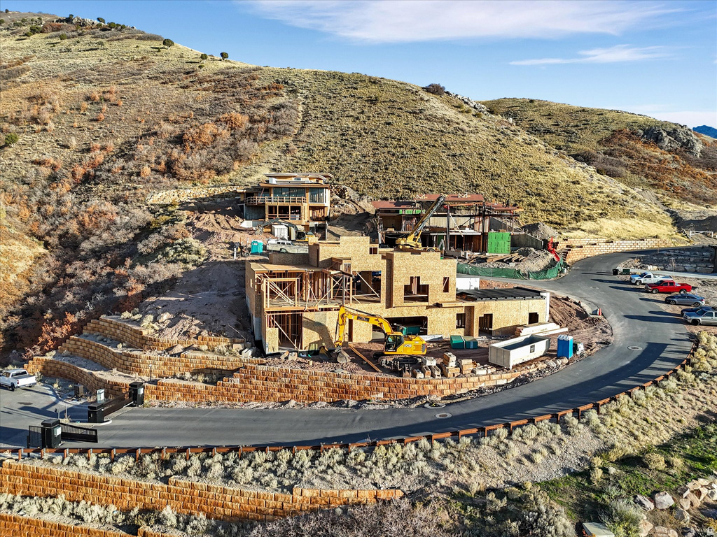 Aerial view of property and surrounding area featuring a mountainous background