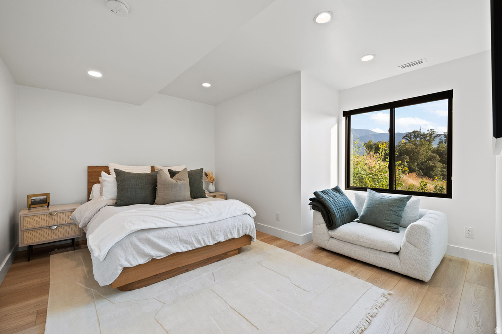 Bedroom with light wood-type flooring, recessed lighting, and a mountain view