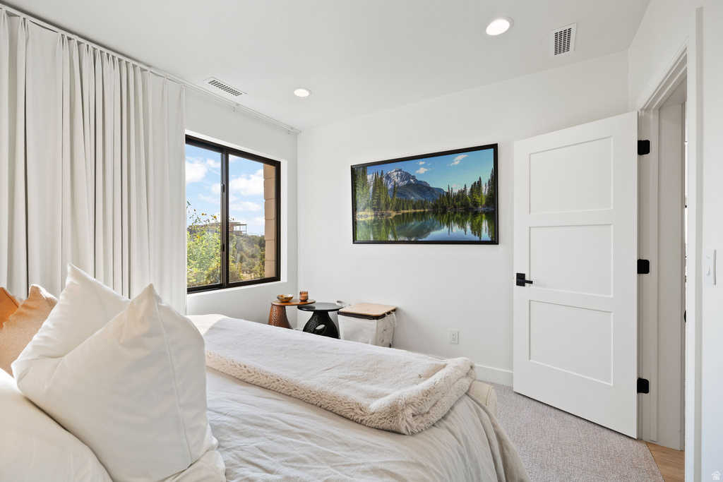 Bedroom with light colored carpet and recessed lighting