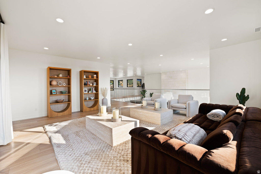Living area with light wood-style floors and recessed lighting