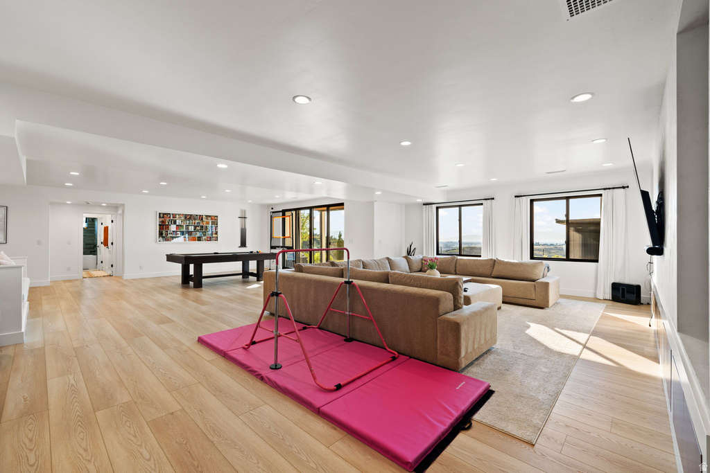 Living area with billiards table, light wood-style flooring, and recessed lighting