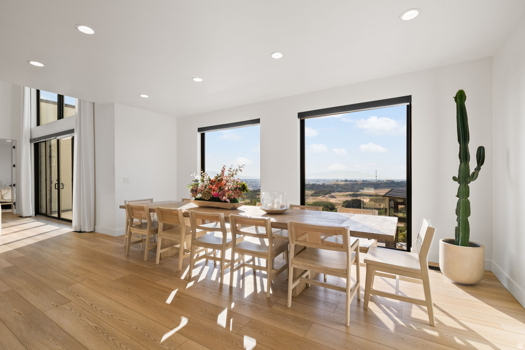 Dining room with light wood-type flooring and recessed lighting