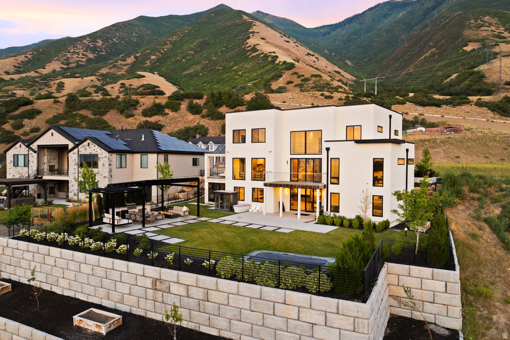 Rear view of property featuring a fenced backyard, a patio area, stucco siding, and a mountain view