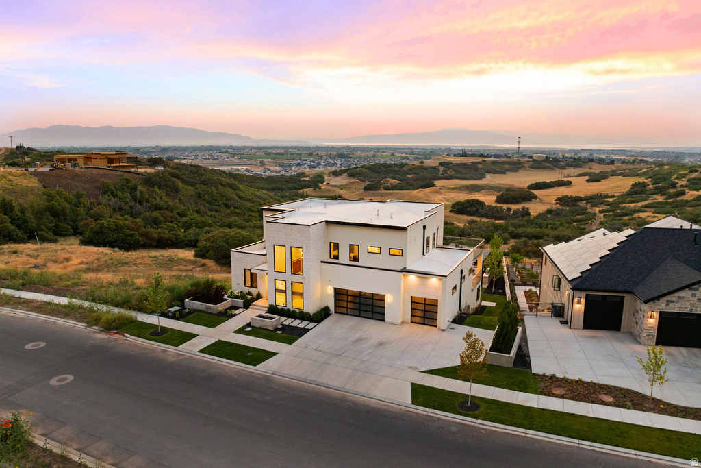 Contemporary house featuring stucco siding, driveway, a mountain view, and a garage