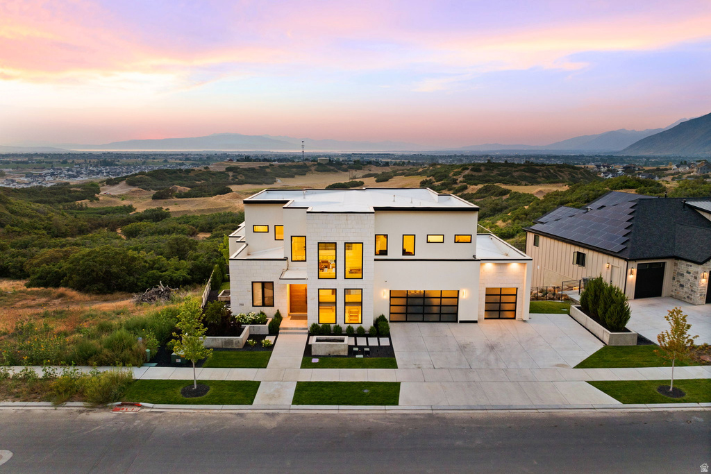 Modern home featuring concrete driveway, stucco siding, and a mountain view