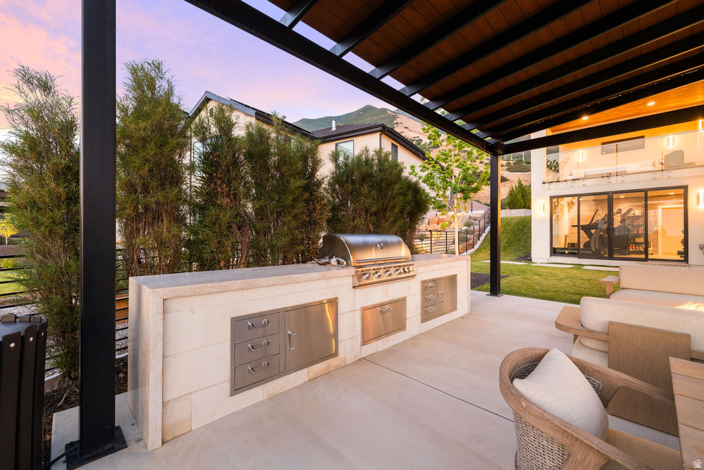 Patio terrace at dusk with a patio area and an outdoor kitchen