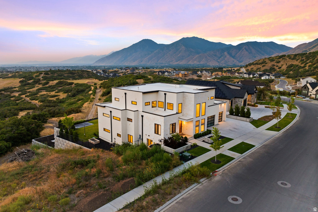 View of front facade with a mountain view, stucco siding, and driveway