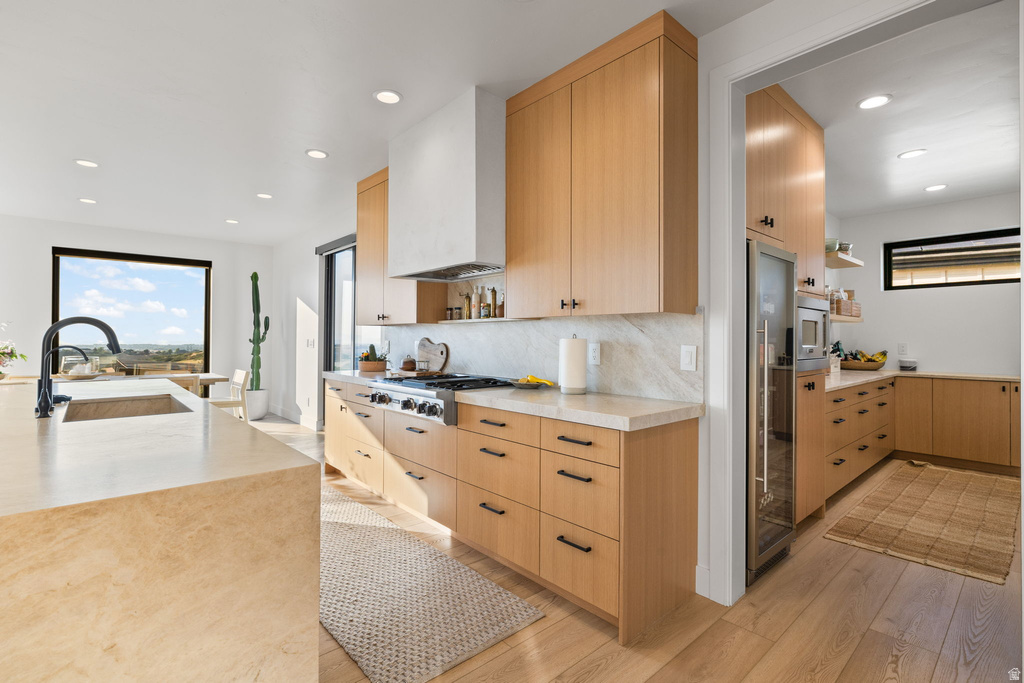 Kitchen with open shelves, light wood finish cabinetry, light stone counters, and recessed lighting
