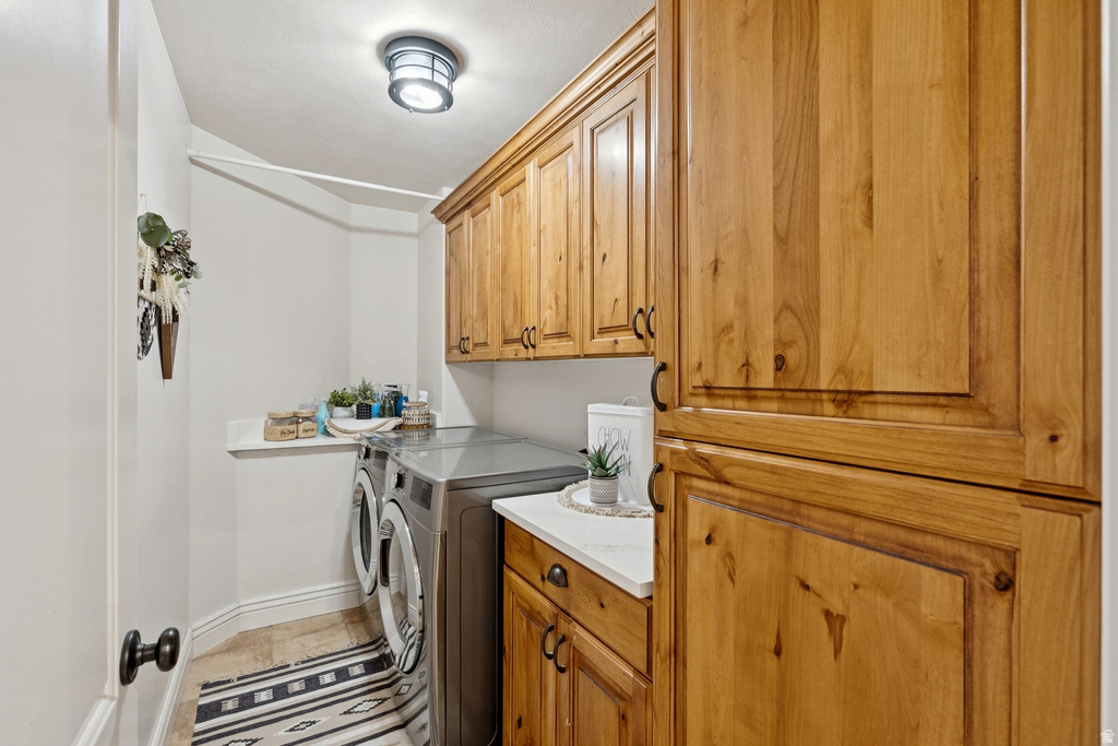 Laundry area featuring washer and clothes dryer and cabinet space